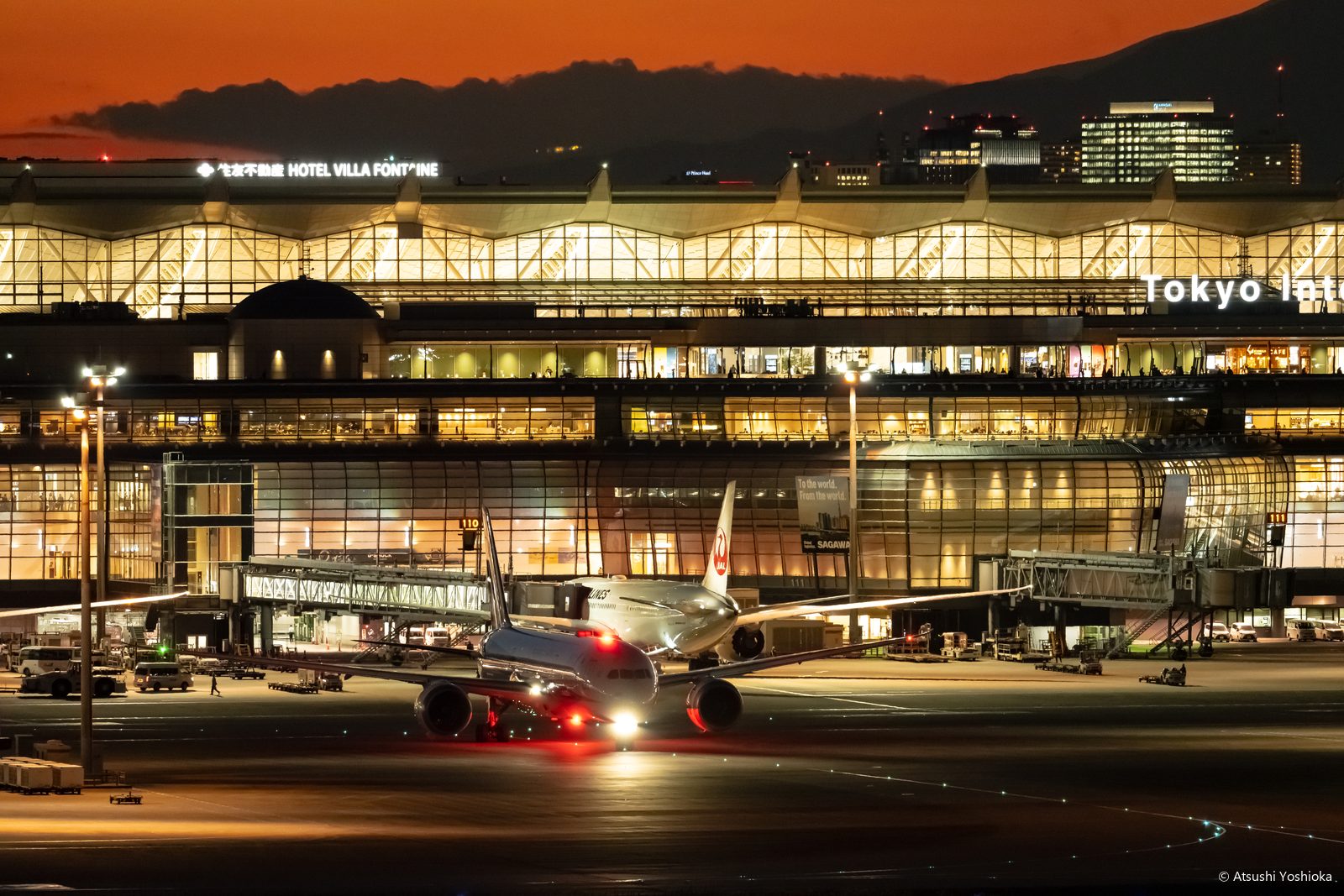 夕焼けの残る空と、明かりのともった羽田空港第3ターミナル
